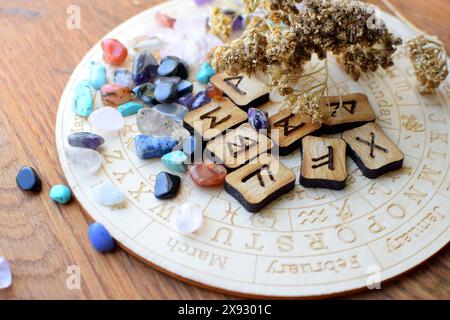 Scandinavian runes made of amethyst and rose quartz crystals on a board with symbols of the zodiac signs. Predictions, witchcraft, spiritual esoteric Stock Photo