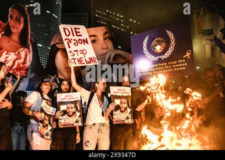 May 25, 2024, Tel Aviv, Israel: Family of Israeli hostage Matan Zangauker hold his photo as they stand next to a bonfire and others hold posters of photos of Israeli female soldier hostages Daniela Gilboa, Liri Elba and Agam Berger with signs saying bring them home, during a demonstration. Tens of thousands of Israelis demonstrated with the hostages families against Prime Minister Benjamin Netanyahu in Tel Aviv, demanding an immediate hostage deal and general elections. Clashes with the Israeli police occurred when protestors did set up bonfires at Kaplan junction. (Credit Image: © Matan Golan Stock Photo