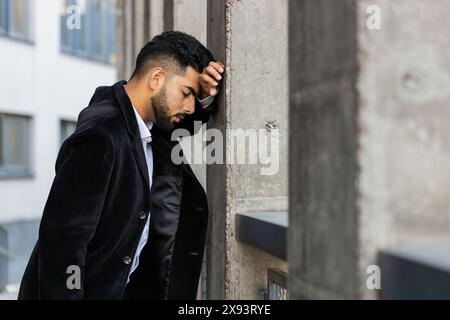 Unhappy sad Indian business man frustrated stress pensive feeling bad after company lost job unemployment problem financial crisis. Arabian Hindu freelancer guy stay at office business center building Stock Photo