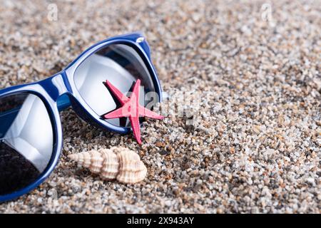 Sunglasses with starfish and seashells on sand Stock Photo