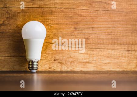 Energy saving light bulb on a wooden table. Led Lightbulb. Stock Photo