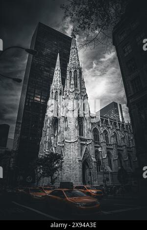 Yellow Taxis passing by St. Patrick's Cathedral under Moody Skies in Selective Color - Manhattan, New York City Stock Photo