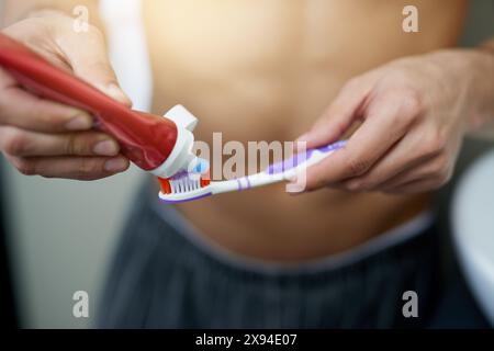 Bathroom, hands and man with toothbrush in home for dental care, getting ready and grooming. Cleaning, health and person with toothpaste, wellness and Stock Photo