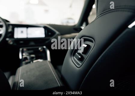 Luxury car seats. Adjustment buttons for the electric seat. Close up view of modern car leather seat at the luxury interior. High quality photo. High Stock Photo