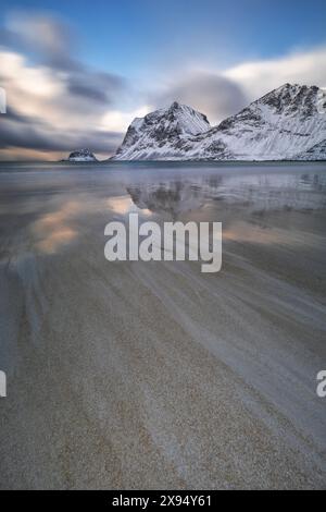 Long exposure to capture the afternoon light in Haukland beach, with snow on the mountain, Lofoten Islands, Nordland, Norway, Scandinavia, Europe Stock Photo