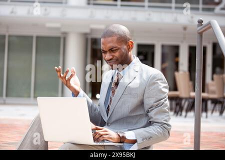 Frustrated business man reading bad news on laptop computer Stock Photo