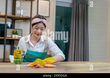 The young woman is wiping/cleaning the table Stock Photo