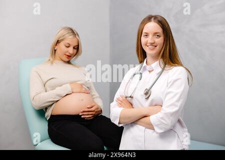 Gynecologist preparing for an examination procedure for a pregnant woman sitting on a gynecological chair in the office and smiling. Stock Photo