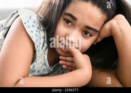 stress little girl biting nails on sofa Stock Photo