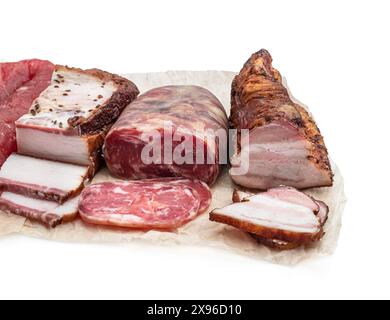 Assorted  dry and smoked meat and sausage in baking paper isolated on white Stock Photo