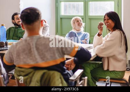 Two focused students writing notes together in a classroom setting, collaborative study, young adults learning, academic teamwork, engaged and concent Stock Photo