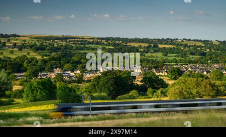 Building constructing houses in scenic rural valley (loss of green field land, loco speeding past) - Burley-in-Wharfedale, West Yorkshire England UK Stock Photo