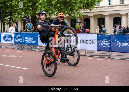 London, UK. 26th May, 2024. A cyclist rides his bicycle on the back wheel on The Mall in London. Thousands of people attended the Ford RideLondon FreeCycle. It is a 7 miles long ride for cyclists of all ages and abilities. Route is traffic free and it is a unique experience to explore central London by bike. The route passes through some of the most famous locations in London like Buckingham Palace, The Mall and St Paul's Cathedral. (Credit Image: © Krisztian Elek/SOPA Images via ZUMA Press Wire) EDITORIAL USAGE ONLY! Not for Commercial USAGE! Stock Photo