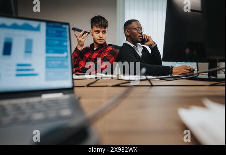 Multicultural office setting with young employees focused on business calls Stock Photo