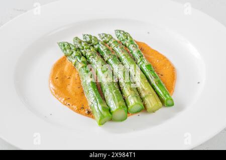 Coocked asparagus with romesco sauce on the plate Stock Photo