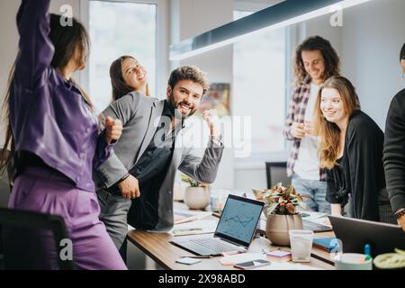 Energetic team celebrating success in creative office meeting Stock Photo