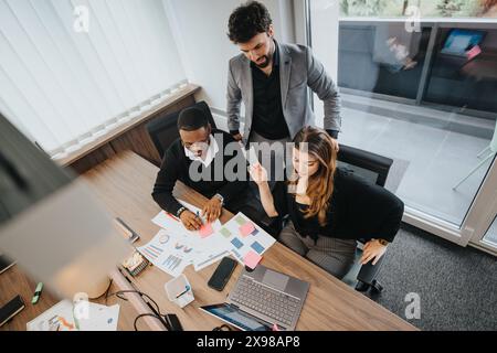 Diverse team of young professionals collaborating on a business project in a modern office Stock Photo