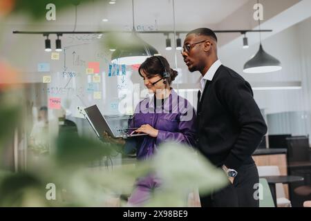 Professional team discussing business strategy with laptop in modern office Stock Photo
