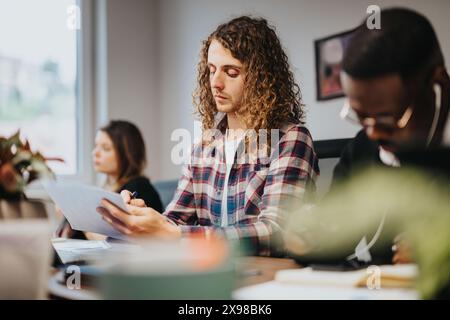 Multicultural team working together in a startup office: young entrepreneurs brainstorming Stock Photo