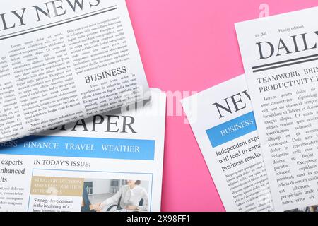Different newspapers on pink background Stock Photo