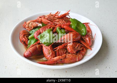 red crayfish with green peppers on a plate for eating Stock Photo