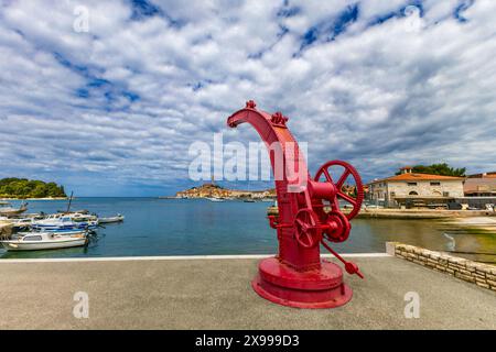 Old red crane in the port of Rovinj, view of the city skyline Church of Saint Euphemia Croatia Stock Photo
