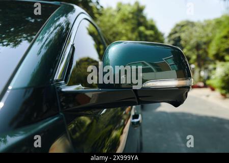 Closeup image of mirror of electric car on road in front of house Stock Photo