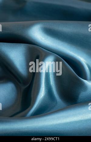 Silk fabric in a beautiful, shimmering teal-blue colour, luxurious textile with a smooth and glossy texture, highlighted by the light reflection Stock Photo
