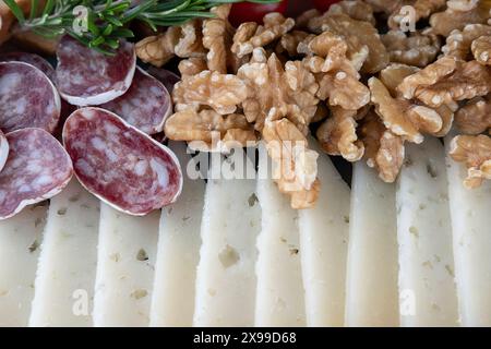 Epicurean selection of delicious cured cheese with an appetizing crumbly texture sliced thinly set near sliced Spanish salchichon and cheeses Stock Photo