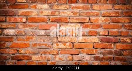Old weathered red brick wall as creative background. Bricks masonry with seams Stock Photo