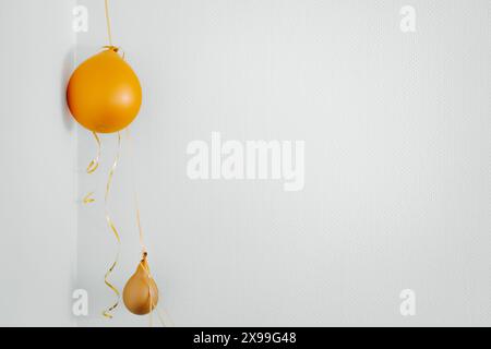 Deflated yellow balloons on golden string white background. After party holiday concept Stock Photo