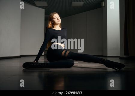 Stiletto dancer performing floorwork routine during dance session Stock Photo