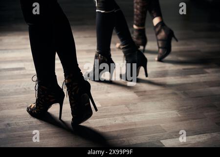 Dancing trio in stilettos striking dance pose Stock Photo