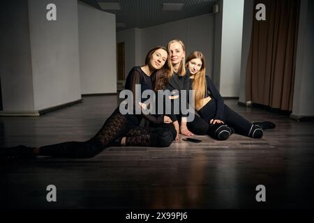 Trio of female dancers resting after dance class in studio Stock Photo