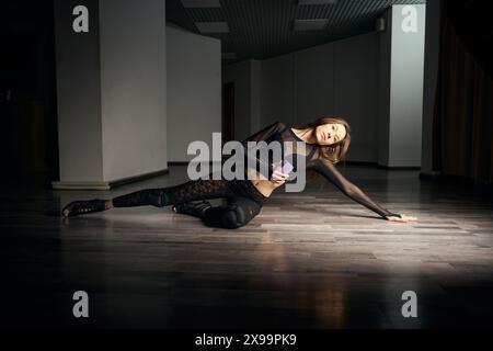 Female dancer performing floorwork choreography in stilettos Stock Photo