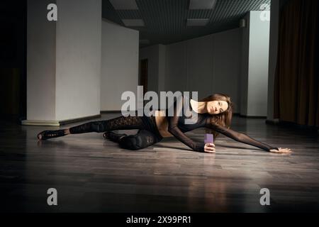 Young female choreographer practicing floorwork moves in high heels Stock Photo