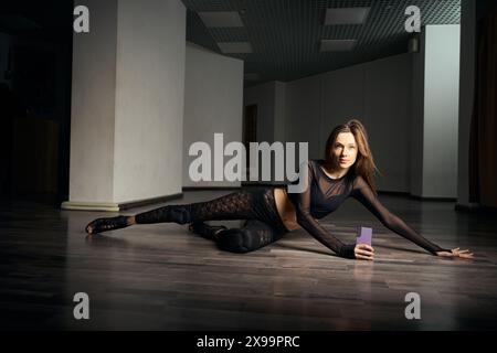 Confident stiletto dancer performing floorwork routine in studio Stock Photo