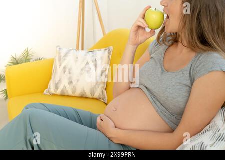 Unrecognizable pregnant woman eating healthy apple Stock Photo