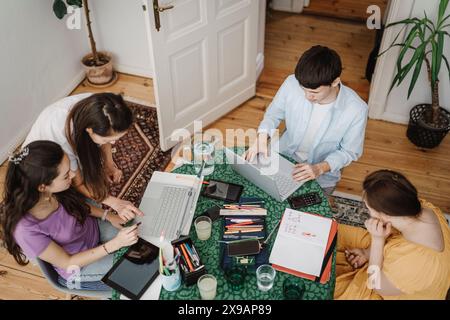 High angle view of mother homeschooling children using laptop on table at home Stock Photo