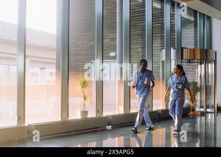 Full length shot of doctors discussing while walking in corridor of hospital Stock Photo