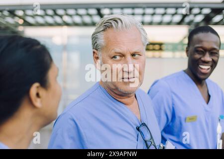 Senior male doctor talking with female colleague Stock Photo