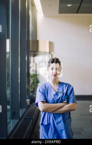 Portrait of confident female doctor standing with arms crossed in hospital Stock Photo