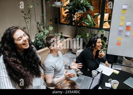 High angle view of happy male and female entrepreneurs discussing during team meeting at office Stock Photo