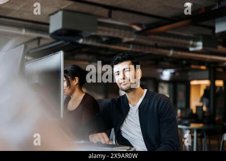 Portrait of smiling male entrepreneur with female colleague at office Stock Photo
