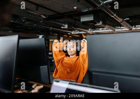 Tired female entrepreneur taking break while sitting at desk in office Stock Photo