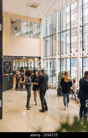 Group of male and female business delegates discussing during seminar at convention center Stock Photo