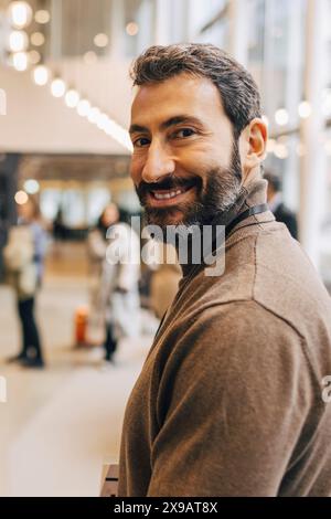 Side view portrait of smiling male entrepreneur at convention center Stock Photo