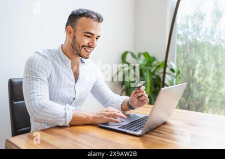 Portrait young mexican attractive businessman working at modern home office with computer laptop Stock Photo