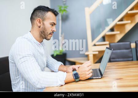 Portrait young mexican attractive businessman working at modern home office with computer laptop Stock Photo
