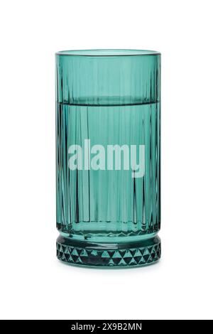 Beautiful blue-green glass tumbler with water poured into it close-up on a white background Stock Photo